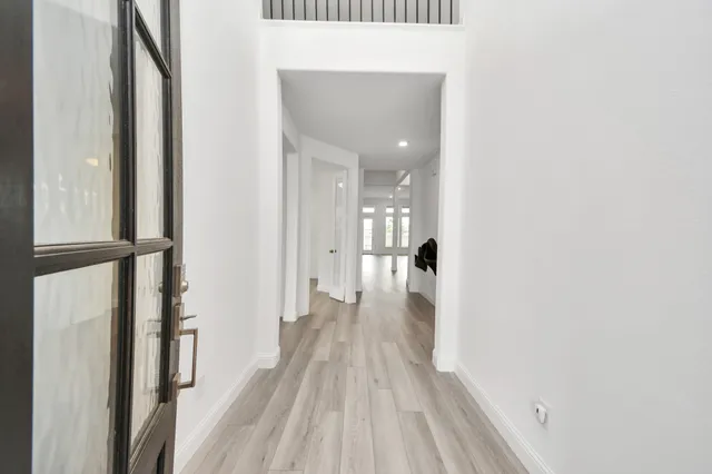 a view of a hallway with wooden floor and staircase