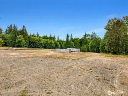 a view of a field with trees in the background