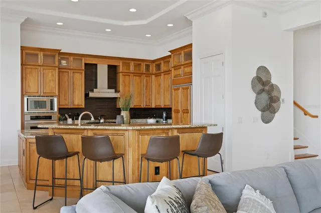 a kitchen with stainless steel appliances granite countertop a stove top oven a sink a dining table and chairs