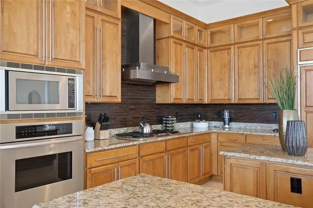 a kitchen with granite countertop kitchen island stainless steel appliances a table and chairs in it