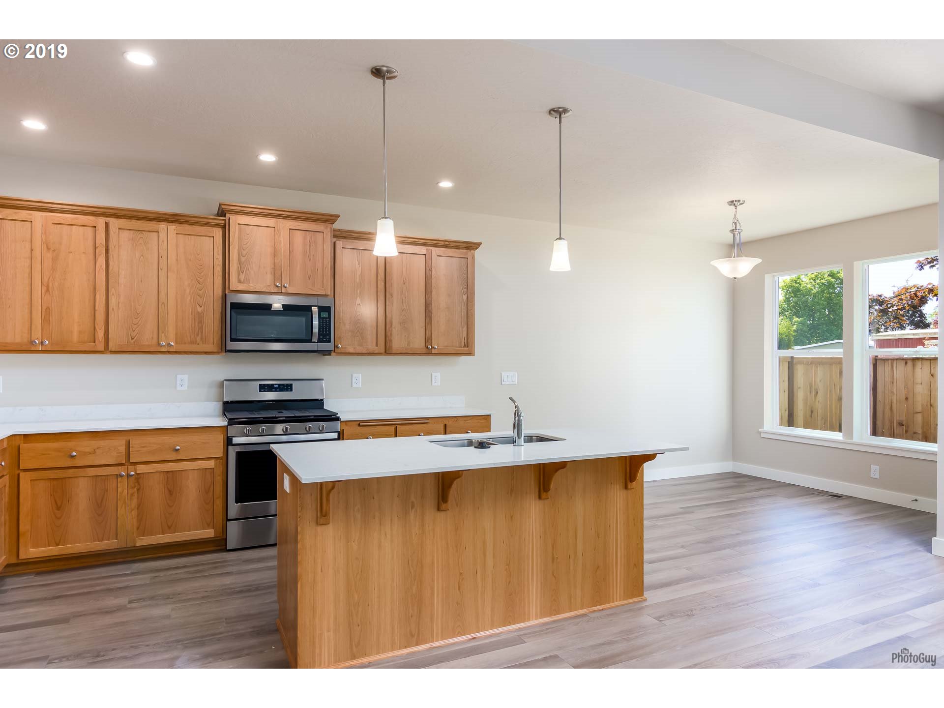 1068 West Olympic Street Springfield, OR 97477 - Photo 12 of 30 a kitchen with stainless steel appliances granite countertop a sink a stove and a wooden floors
