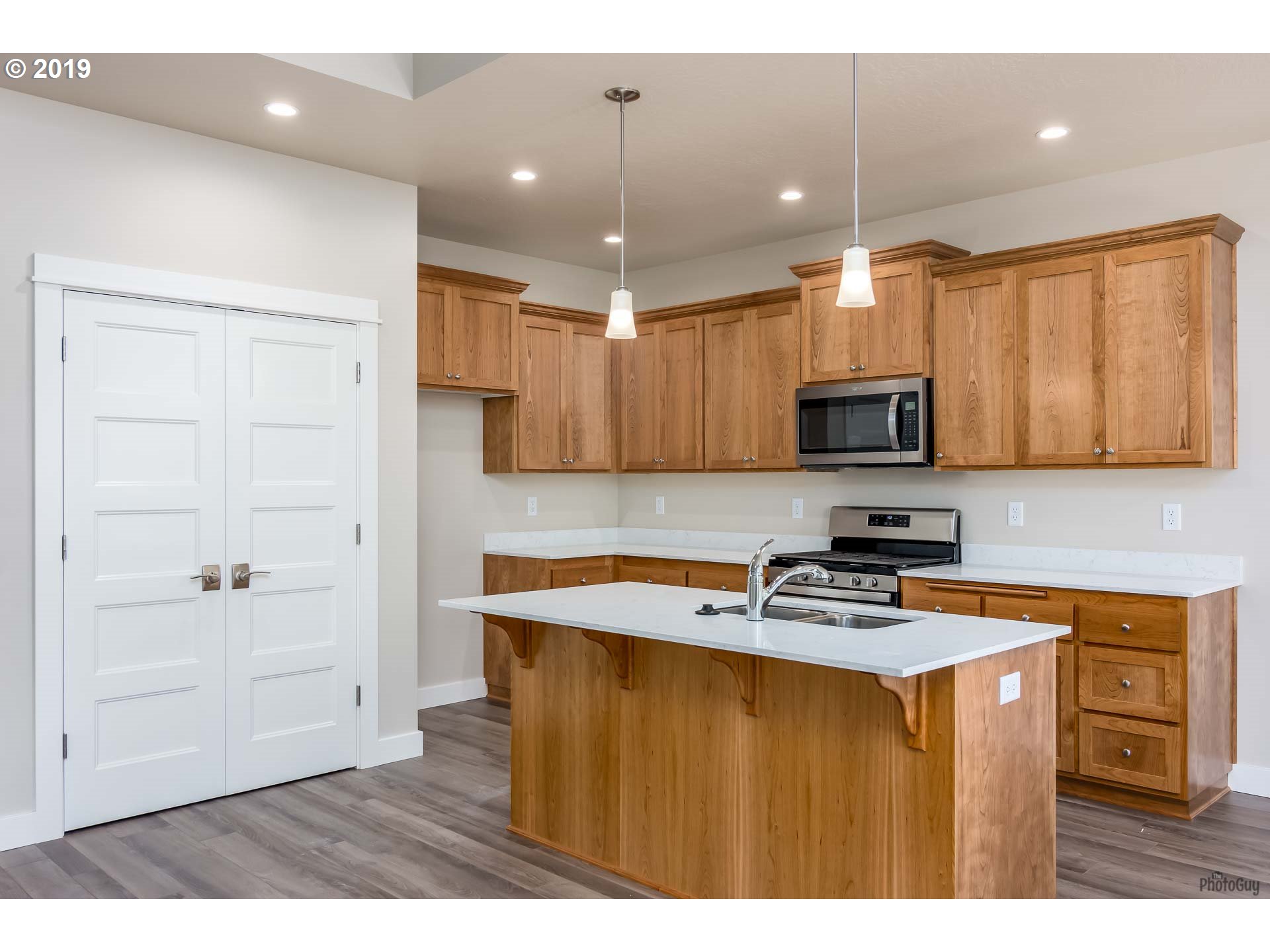 1068 West Olympic Street Springfield, OR 97477 - Photo 17 of 30 a kitchen with kitchen island white cabinets appliances and a center island