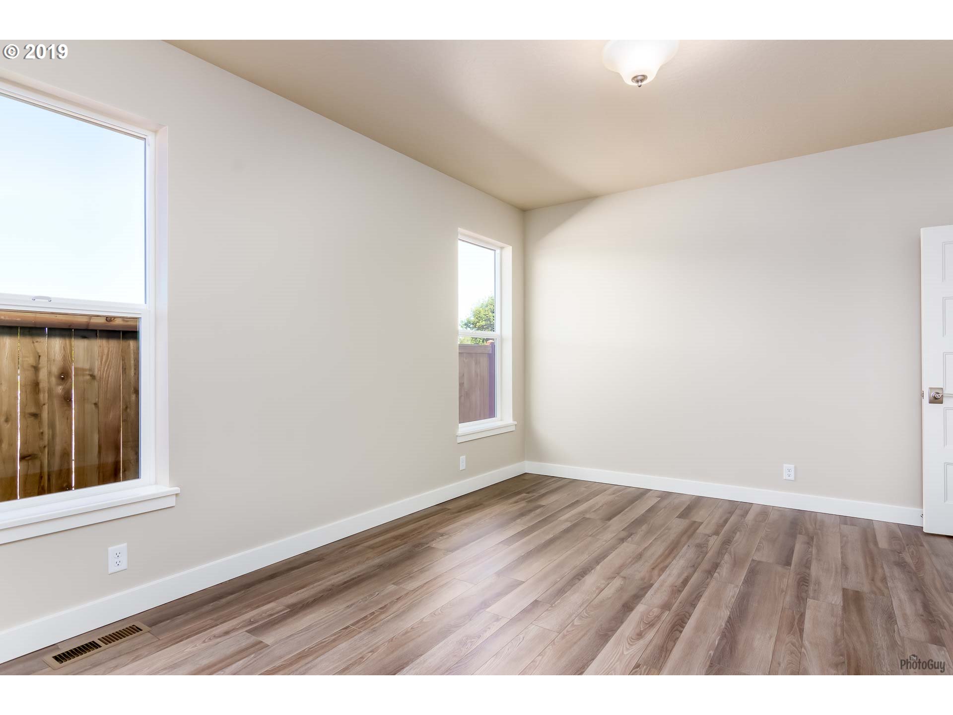 1068 West Olympic Street Springfield, OR 97477 - Photo 21 of 30 a view of an empty room with wooden floor and a window