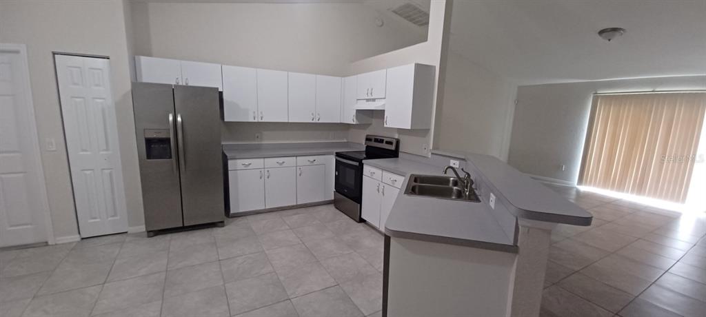 8799 Southwest 66th Avenue Ocala, FL 34476 - Photo 3 of 28 a kitchen with a sink stove and refrigerator