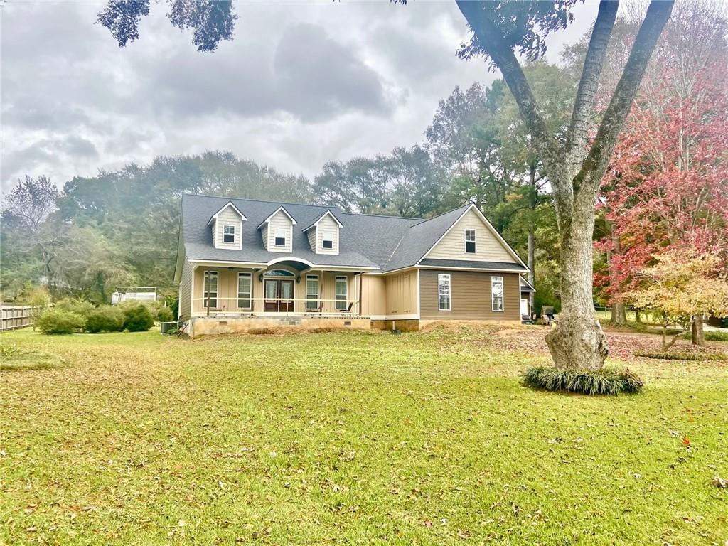 a front view of a house with a yard and trees