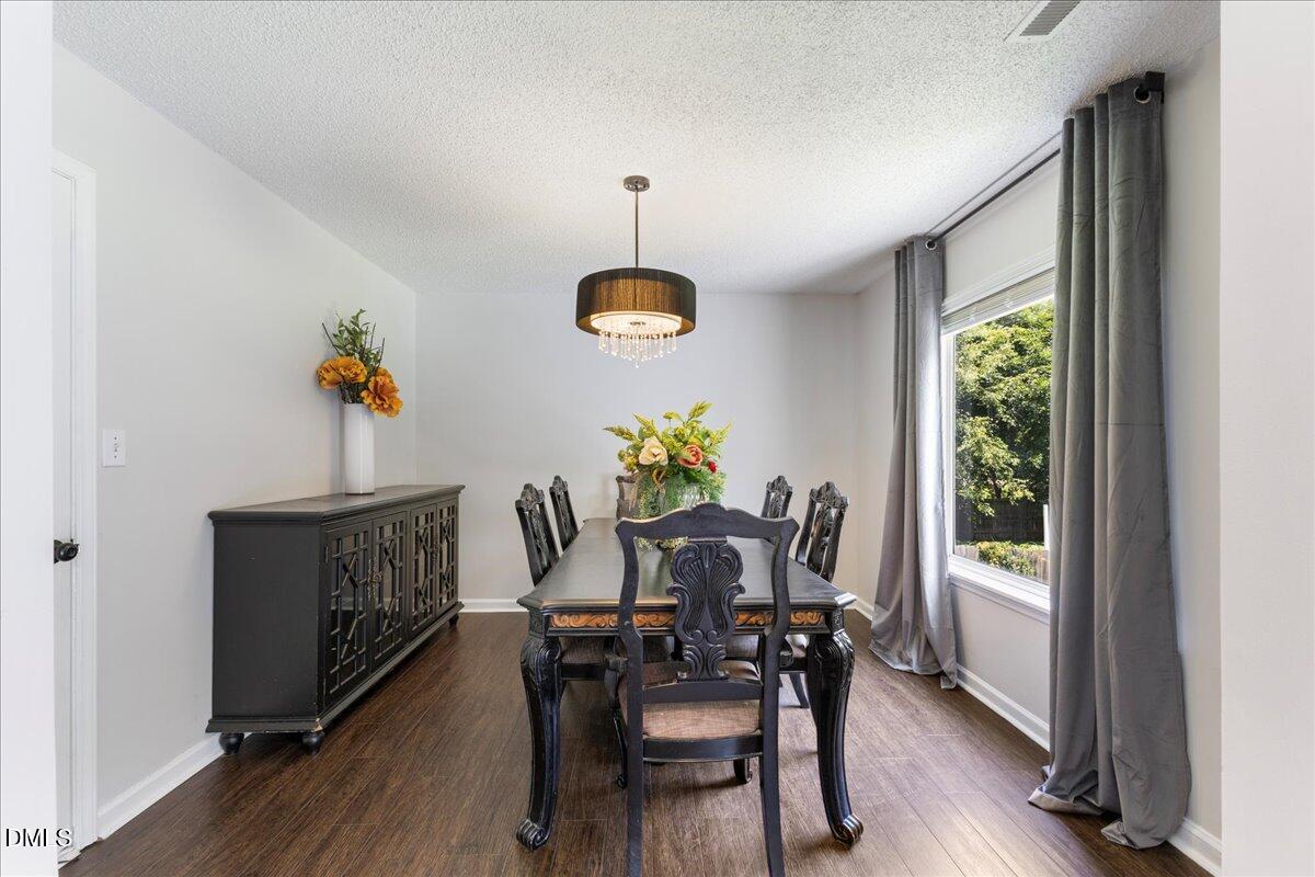 4708 River Boat Landing Court Raleigh, NC 27604 - Photo 16 of 61 a dining room with furniture a chandelier and wooden floor