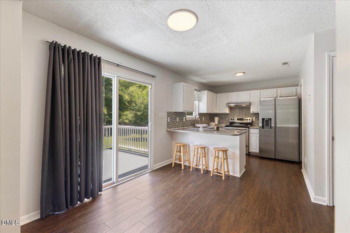 4708 River Boat Landing Court Raleigh, NC 27604 - Photo 18 of 61 a kitchen with white cabinets and stainless steel appliances