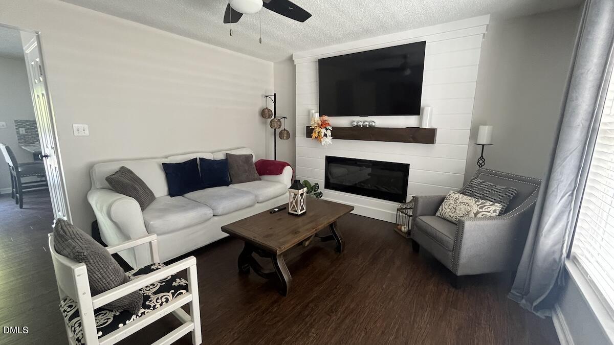 4708 River Boat Landing Court Raleigh, NC 27604 - Photo 7 of 61 a living room with furniture a flat screen tv and a fireplace