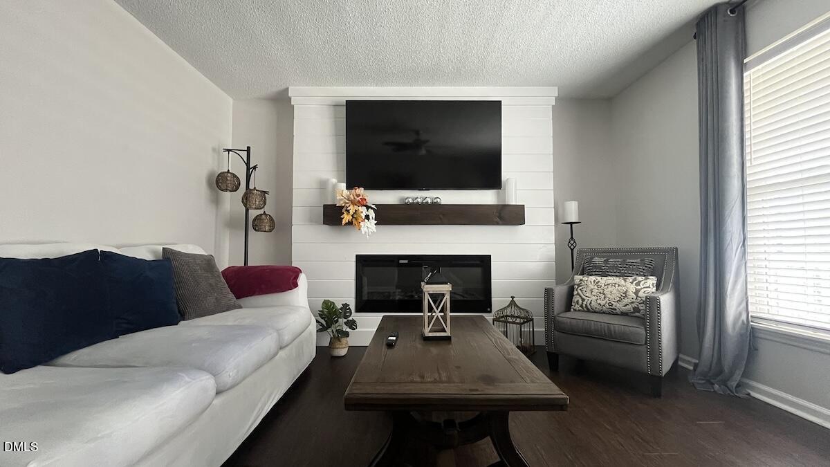 4708 River Boat Landing Court Raleigh, NC 27604 - Photo 9 of 61 a living room with furniture a flat screen tv and a fireplace