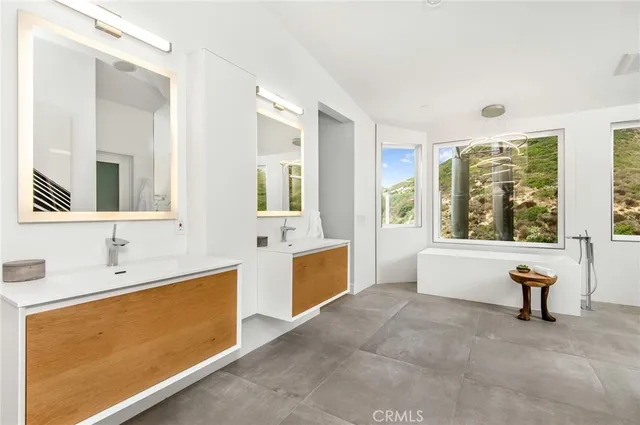 a spacious bathroom with a tub sink and mirror
