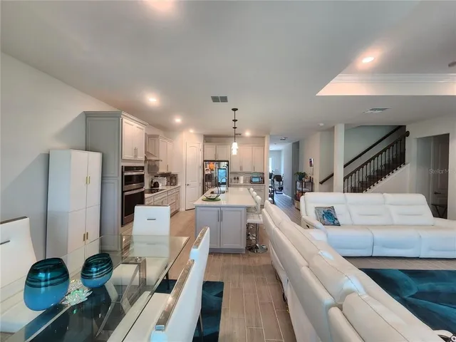a large white kitchen with lots of counter space and stainless steel appliances