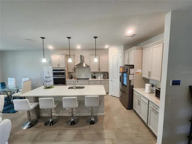 a large kitchen with a table and chairs