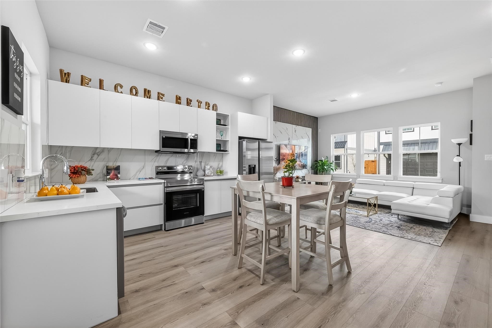 6702 Metro Boulevard, Unit 2 Houston, TX 77083 - Photo 12 of 39 a kitchen with stainless steel appliances a white table and chairs