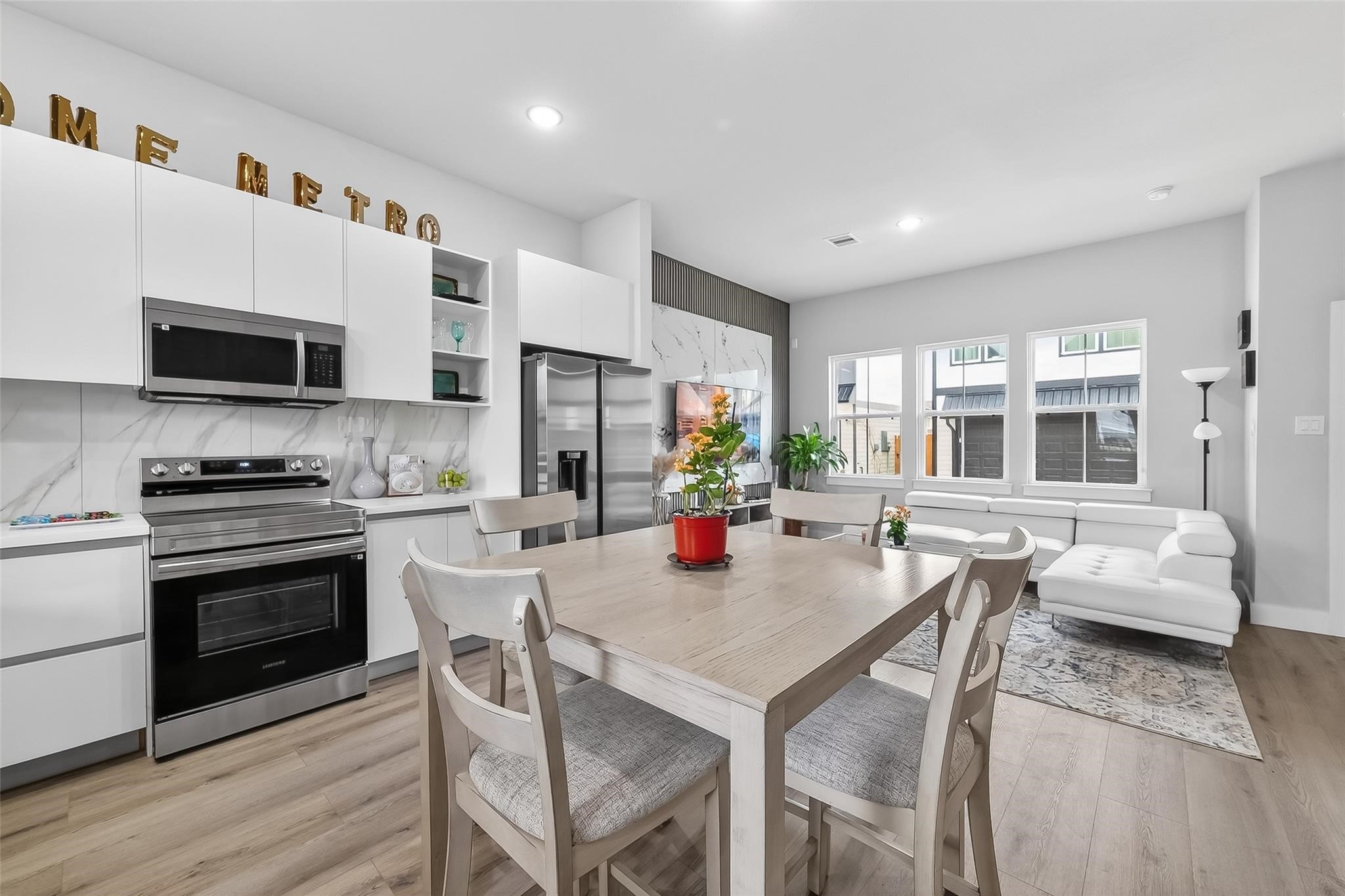 6702 Metro Boulevard, Unit 2 Houston, TX 77083 - Photo 13 of 39 a kitchen with stainless steel appliances granite countertop a stove a refrigerator a kitchen island a dining table and chairs