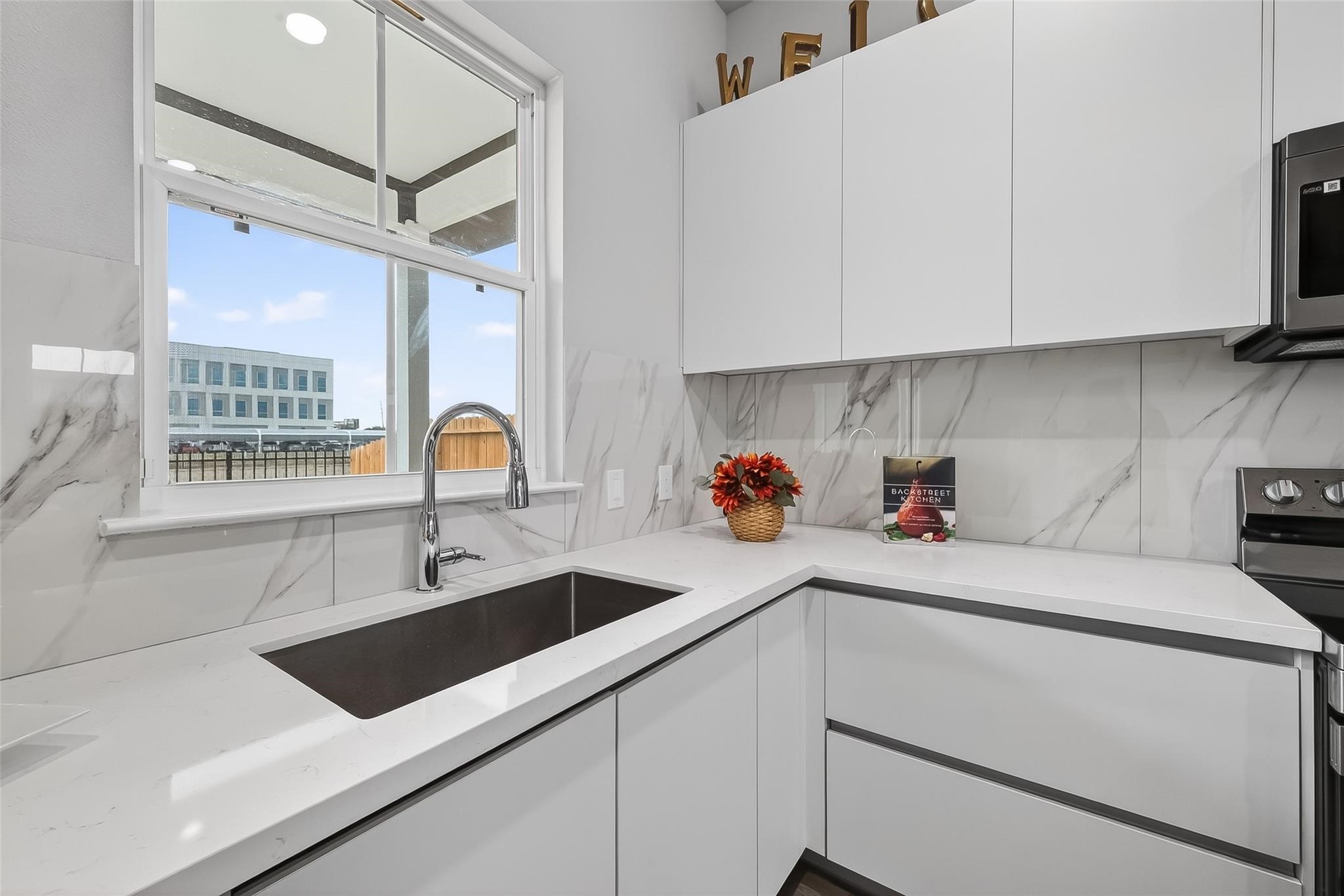 6702 Metro Boulevard, Unit 2 Houston, TX 77083 - Photo 15 of 39 a kitchen with sink a microwave and cabinets