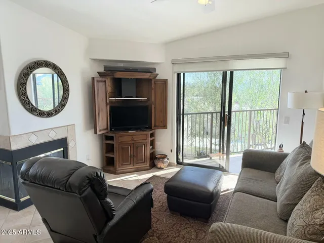 a living room with furniture a large window and a flat screen tv