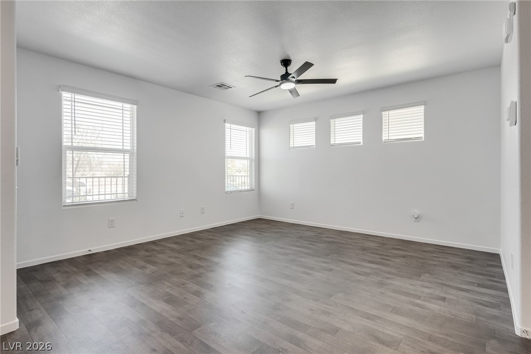 1114 Scarlet Sparrow Street Henderson, NV 89011 - Photo 6 of 25 A well-lit interior features durable laminate flooring and a modern ceiling fan.