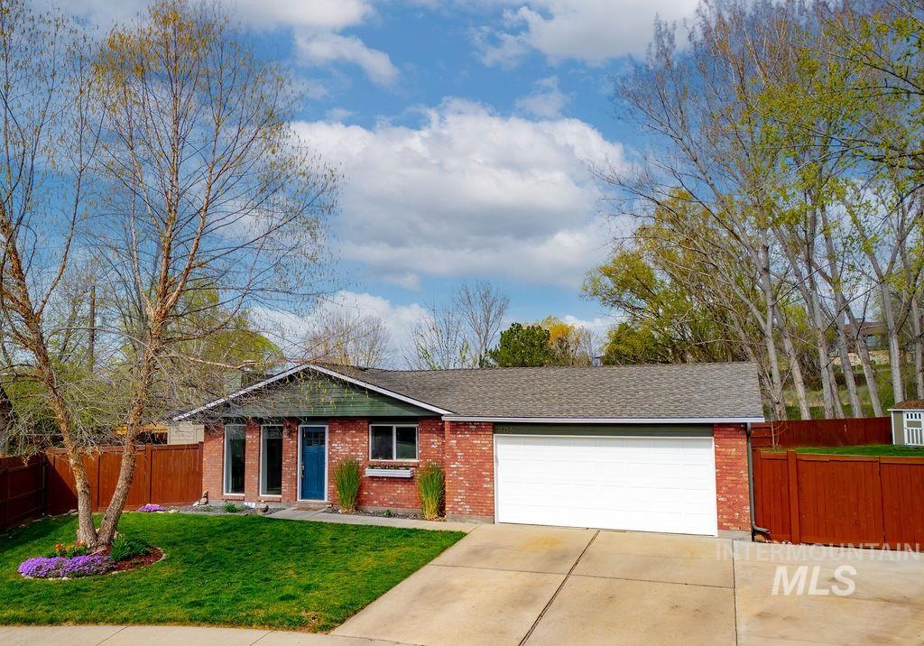 Ranch-style home with an attached garage, concrete driveway, brick siding, and a shingled roof
