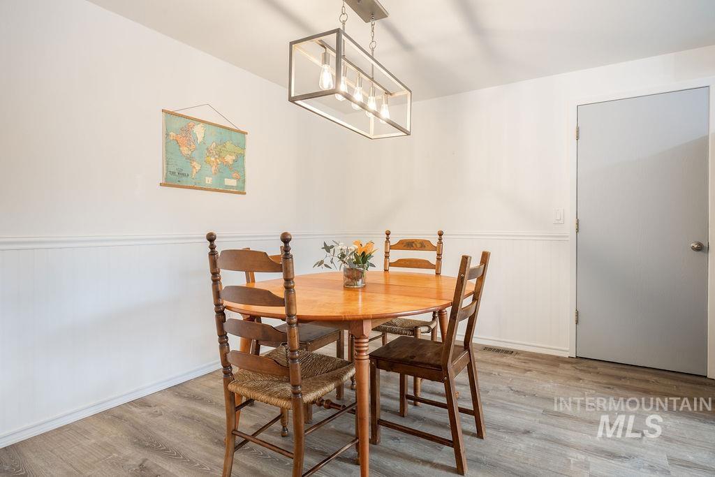 405 North 2nd Street Eagle, ID 83616 - Photo 11 of 39 Dining area with wainscoting, light wood-type flooring, and hanging lights