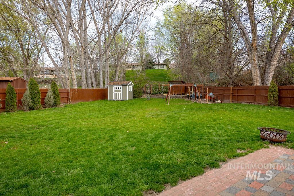 405 North 2nd Street Eagle, ID 83616 - Photo 32 of 39 Fenced backyard with an outdoor fire pit and a shed