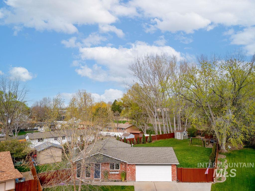 405 North 2nd Street Eagle, ID 83616 - Photo 39 of 39 View of front facade with brick siding, a storage shed, an attached garage, driveway, and a residential view