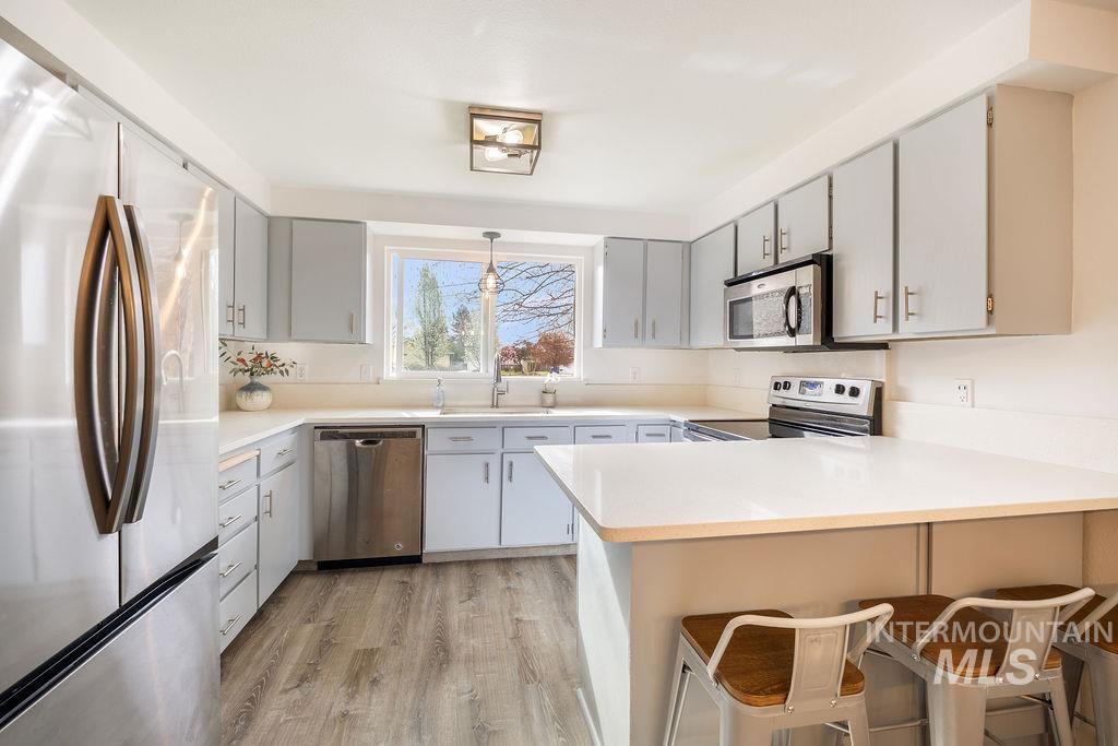 405 North 2nd Street Eagle, ID 83616 - Photo 7 of 39 Kitchen featuring stainless steel appliances, a peninsula, a breakfast bar, light countertops, and light wood finished floors