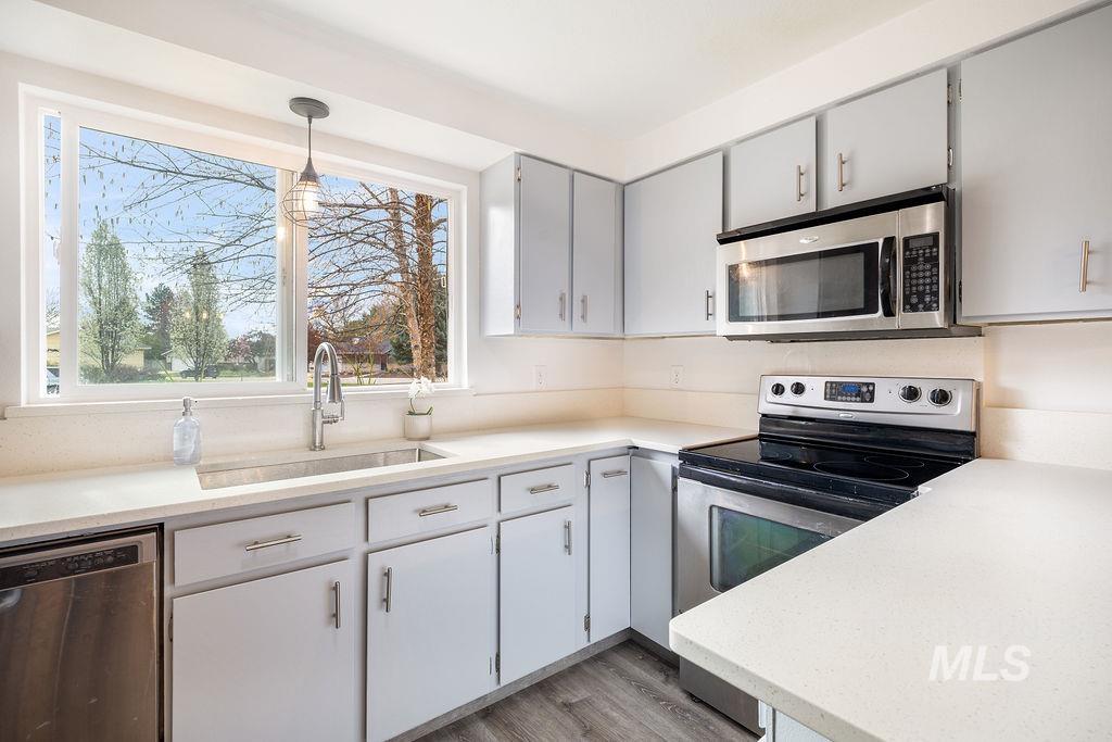 405 North 2nd Street Eagle, ID 83616 - Photo 8 of 39 Kitchen with stainless steel appliances, pendant lighting, light wood-style floors, and light stone counters