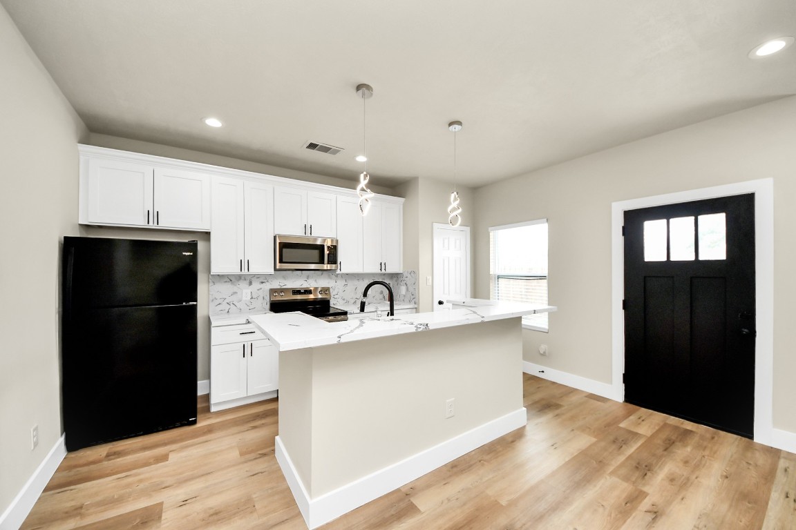 5211 Amy Street, Unit B Houston, TX 77028 - Photo 5 of 17 a kitchen with stainless steel appliances a refrigerator stove and sink