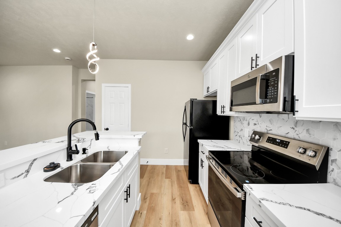 5211 Amy Street, Unit B Houston, TX 77028 - Photo 6 of 17 a kitchen with stainless steel appliances a sink a stove top oven a refrigerator with granite countertops and cabinets