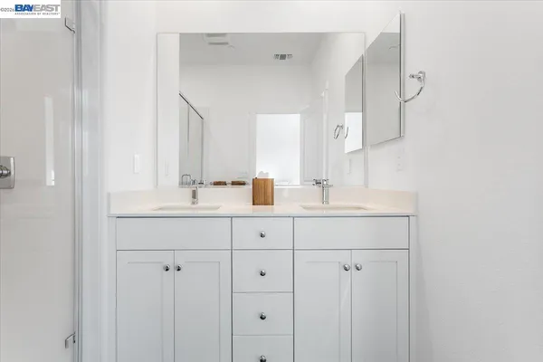 a bathroom with double sink and a mirror