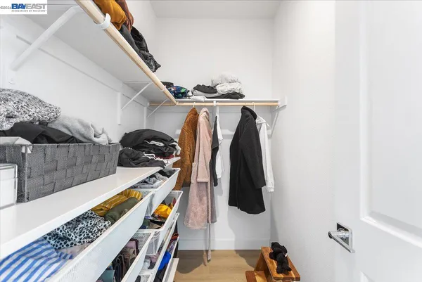 a view of walk in closet with clothes and shoes