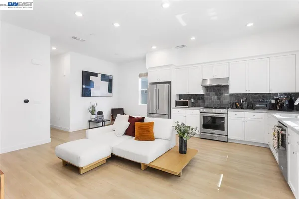 a living room with furniture and kitchen