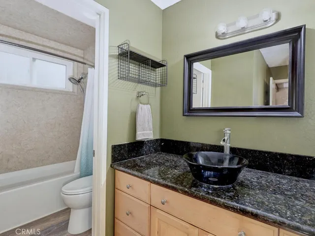 a bathroom with a granite countertop sink a toilet and a bathtub