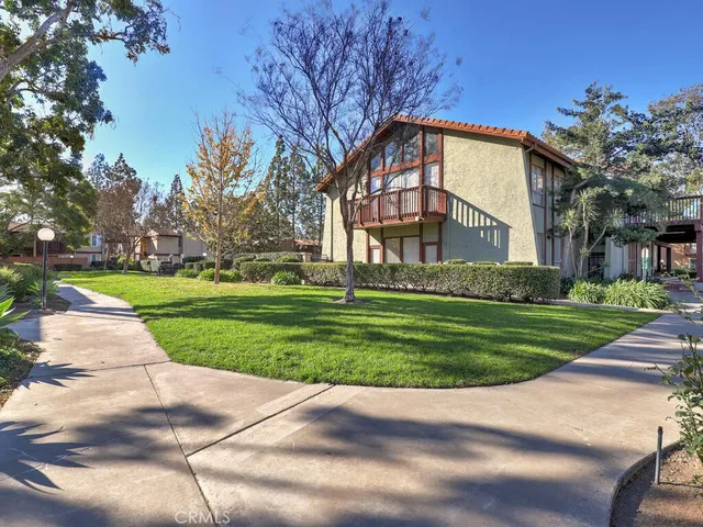 a view of a big house with a big yard and large trees