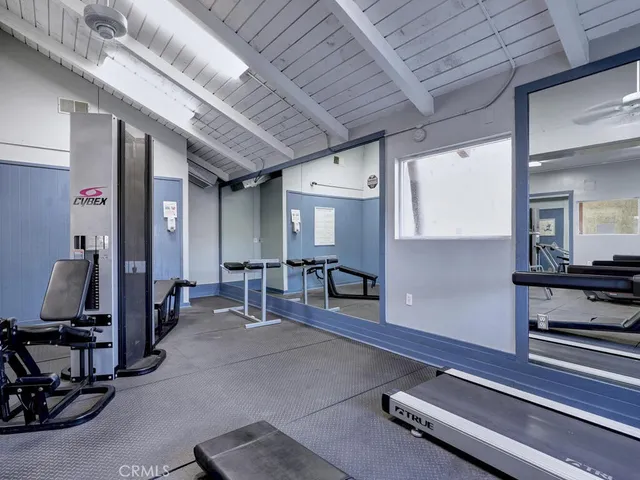 a room with gym equipment and large mirror