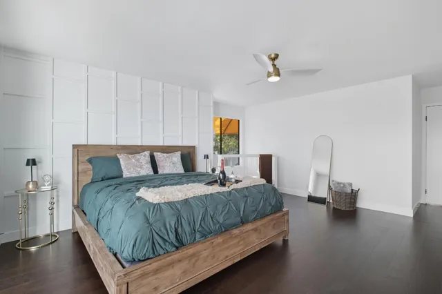 a bedroom with a bed and wooden floor