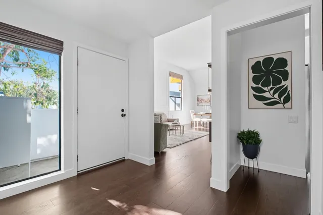 a view of empty room with wooden floor and window