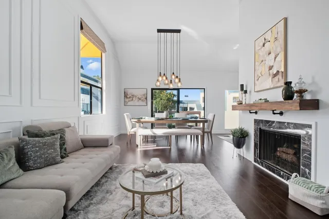 a living room with furniture a fireplace and a large window