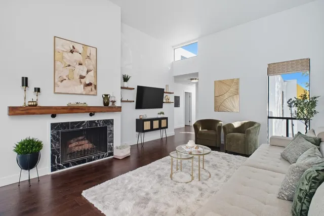 a living room with furniture a fireplace and a flat screen tv