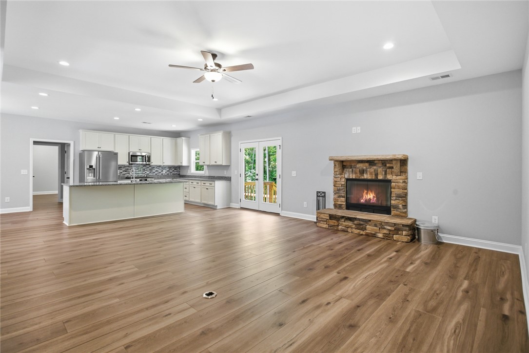 912 Watercrest Road West Union, SC 29696 - Photo 5 of 49 This expansive great room seamlessly connects living and kitchen spaces, featuring a cozy fireplace.