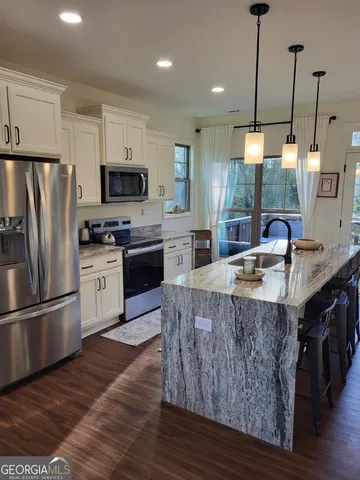 a kitchen with stainless steel appliances granite countertop a sink a stove and a refrigerator