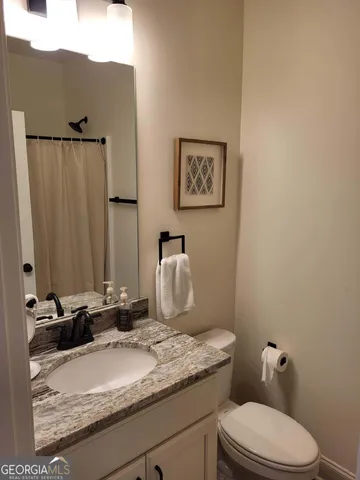 a bedroom with a bed and a lamp on dresser