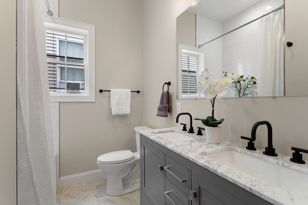 32 Wentworth Street, Unit 2 Boston, MA 02124 - Photo 19 of 23 a bathroom with a granite countertop toilet sink and mirror