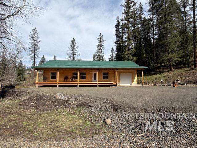 124 Windmill Lane Kooskia, ID 83539 - Photo 2 of 50 View of front of home with a porch, a metal roof, driveway, and an attached garage