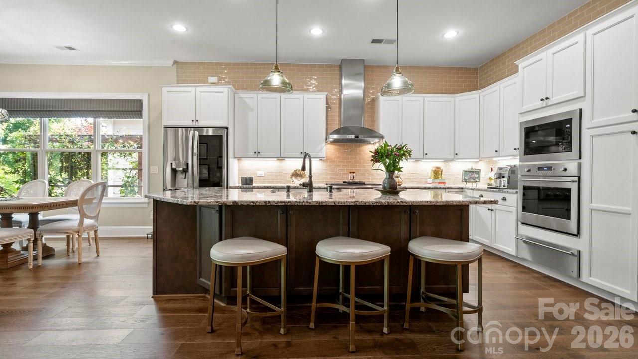 4854 Looking Glass Trail Denver, NC 28037 - Photo 10 of 48 a kitchen with stainless steel appliances granite countertop a stove a refrigerator a kitchen island a dining table and chairs with wooden floor