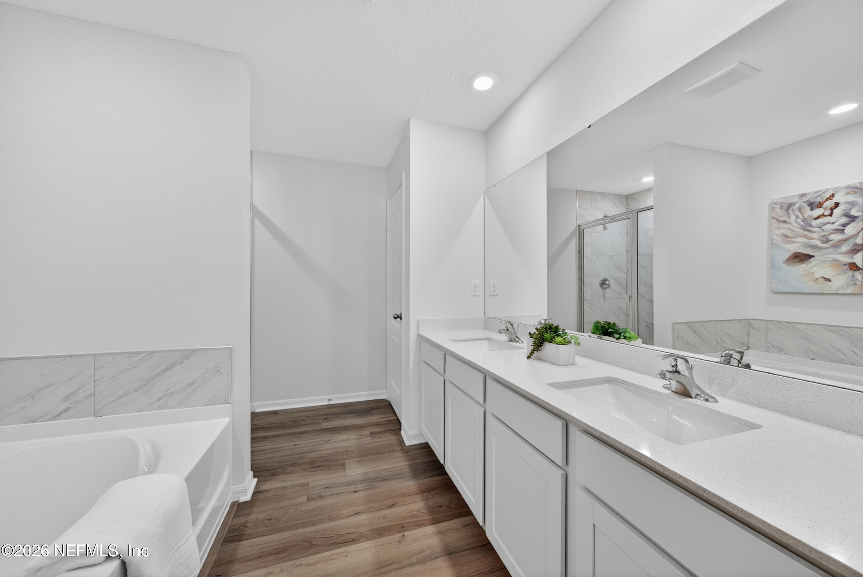 6855 Myrtle Oak Road Jacksonville, FL 32219 - Photo 8 of 27 a bathroom with a double vanity sink and mirror with bathtub