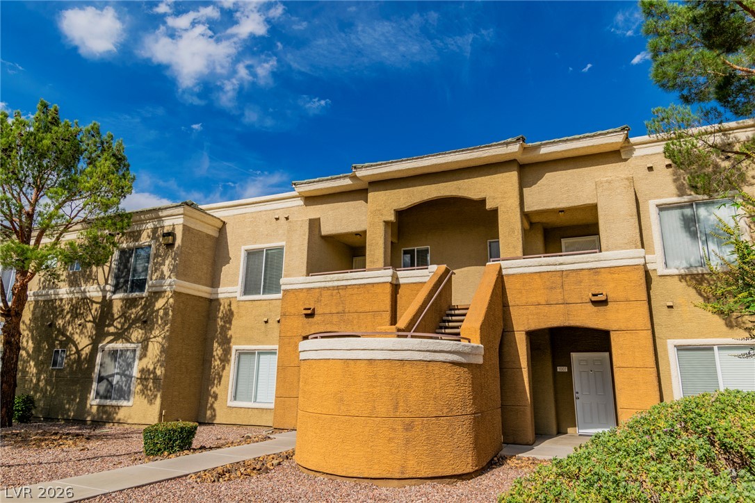 Multi-level residential building offers ample natural light with mature landscaping and clear sky views.