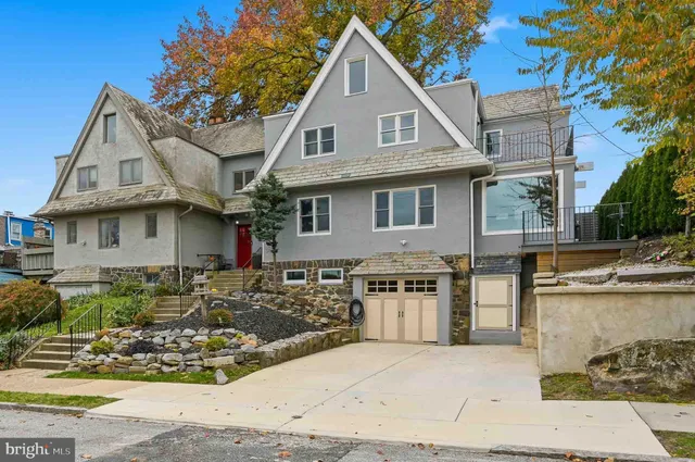a view of a white house with large windows next to a road