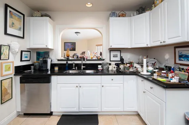 a kitchen with white cabinets and sink