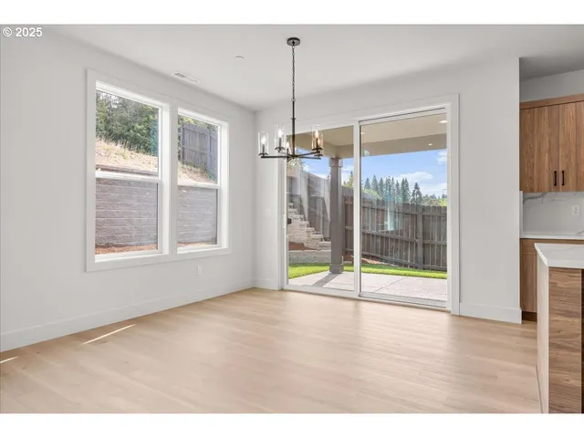 a view of an empty room with glass door and windows